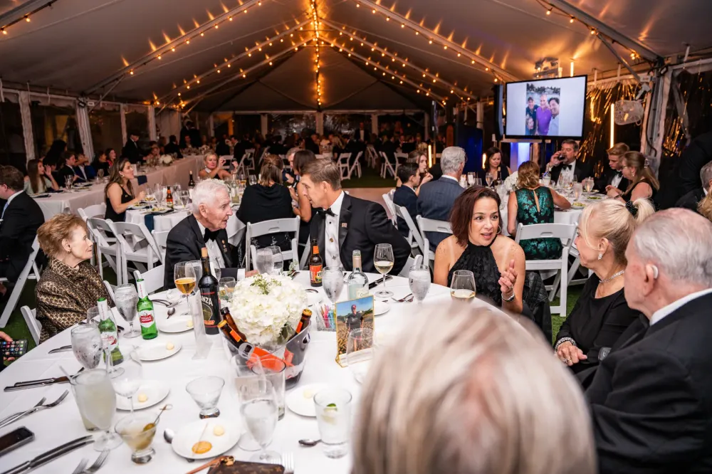 The gala tent glowing with string lights over a full dinner crowd